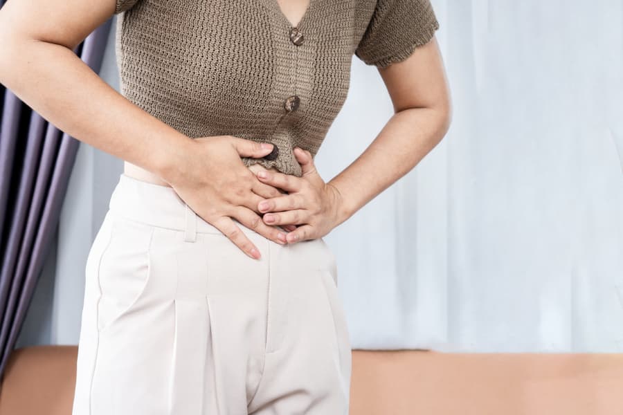 Female patient hunched over while experiencing pelvic pain