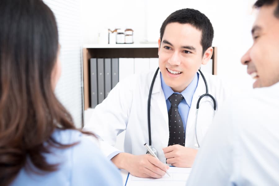 Physician consults with young couple seeking information about vasectomy