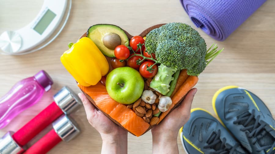 Heart-shaped bowl of food with exercise equipment