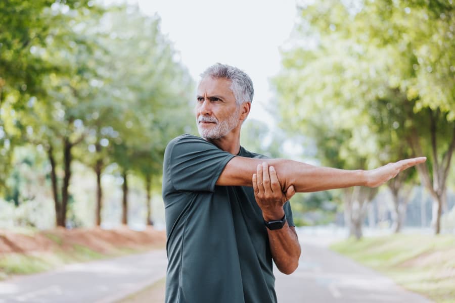 Older person stretching in public park