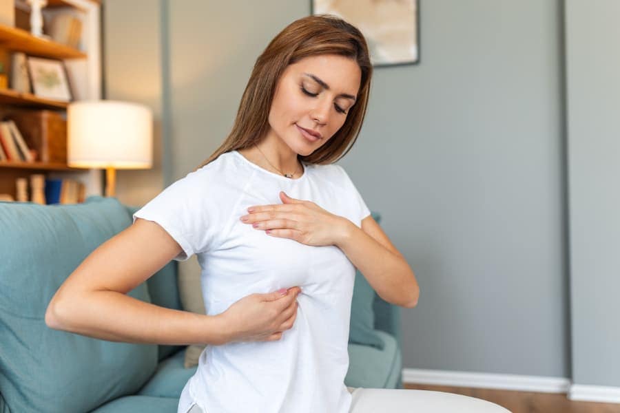 Young person performing self-examination of breasts