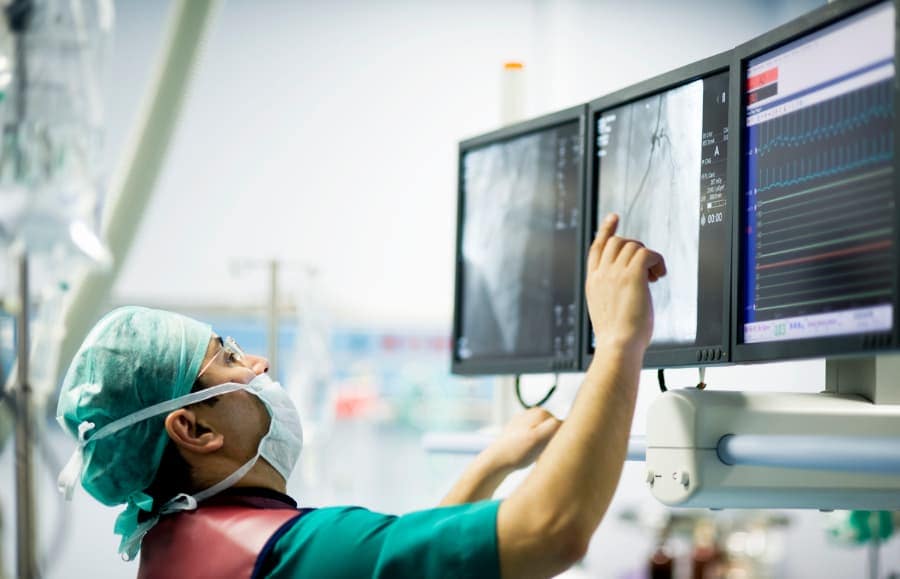 : Cardiologist looks at X-ray in operating room