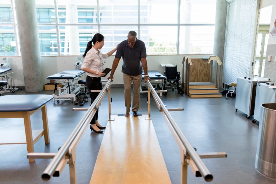 Physical therapist helps stroke patient with balance training