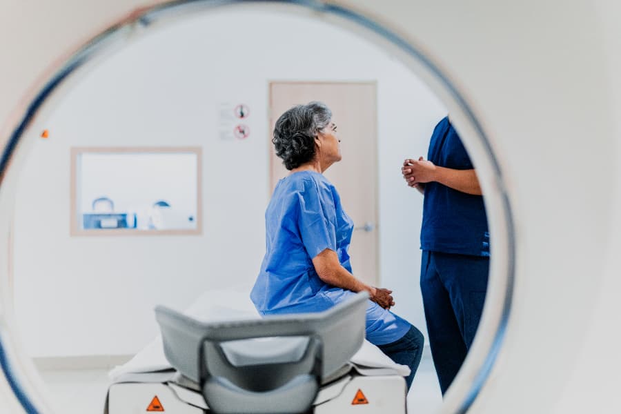 Patient on MRI scan table talking to nurse