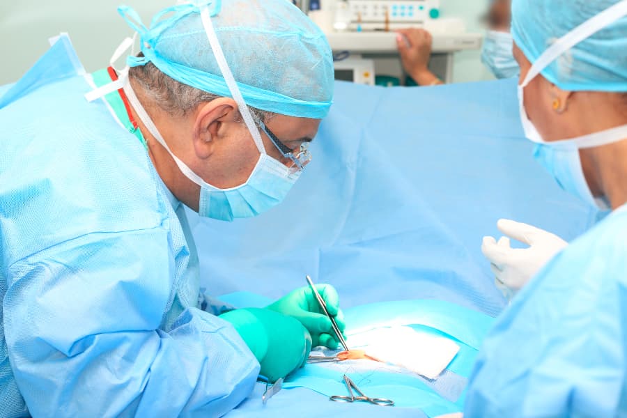 Surgeon performing abdominal hernia repair in operating room
