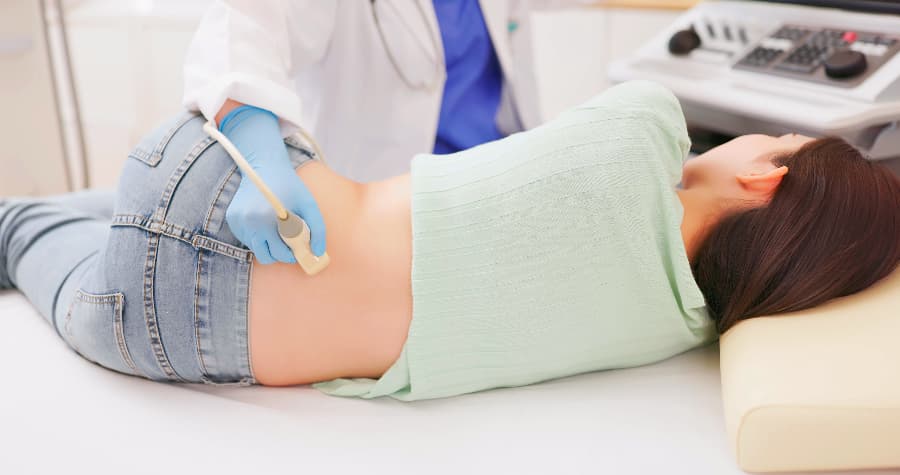 Physician using ultrasound to inspect young patient